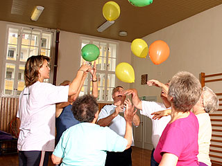 Die Rehasport-Gruppe spielt sich Luftballons zu.
